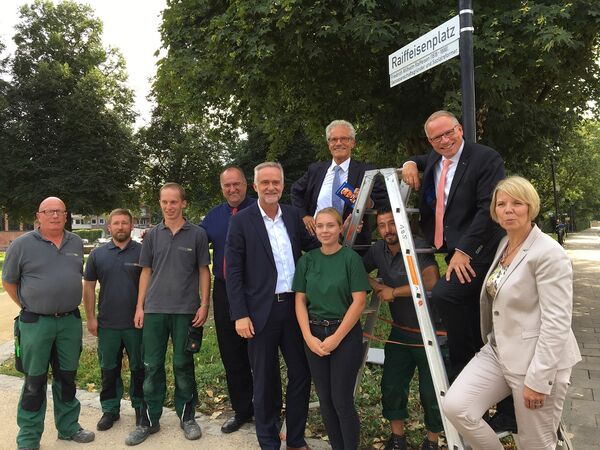 Raiffeisenplatz Enthüllung Straßenschild mit Azubis.